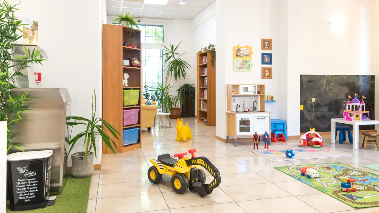 Panoramica Hall con area giochi e angolo lettura, macchina dell'acqua.